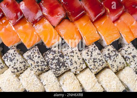 Assorted sushi nigiri and maki set close up. A variety of Japanese sushi with tuna, salmon, sesame. Top view, flat lay, wallpaper, background. Stock Photo