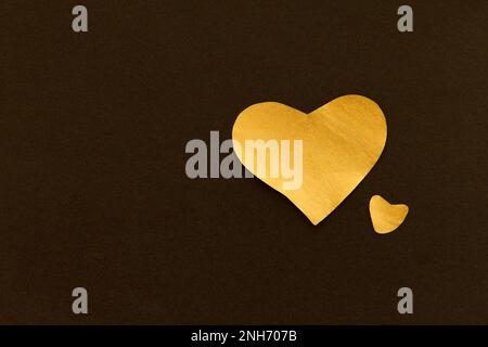 Golden sparkling heart on a black background, made of paper, romantic and festive beautiful symbol, background Stock Photo