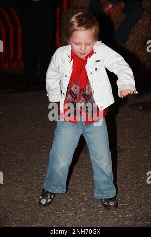 Little boy dancing wearing blue jeans, a red shirt and white jean jacket and has on tennis shoes. Stock Photo