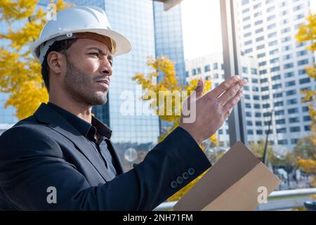 Experienced architect, constructor engineer in protective white helmet in construction. Stock Photo