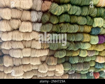 A background of skeins of wool in natural tones and green shades. Stock Photo