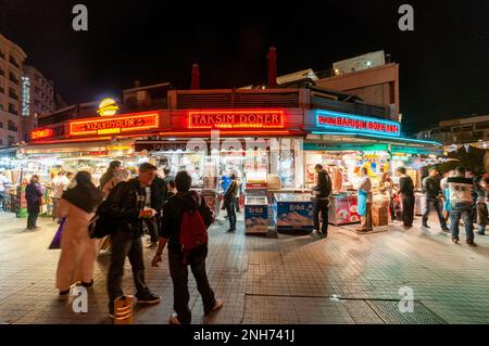 People waiting and eating in front of wet burger and doner kebab buffets at the entrance of Beyoglu avenue, Istanbul, Turkey (2013) Stock Photo