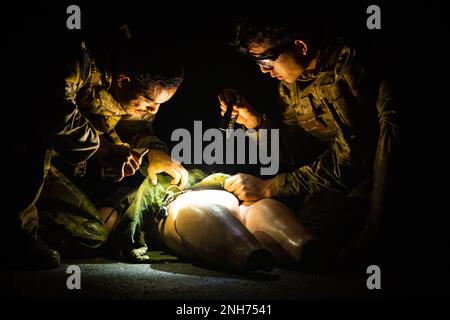 U.S. Airmen and Marines from Misawa Air Base, Andersen Air Force Base, Kadena Air Base and Marine Corps Air Station Iwakuni gather to disarm a suicide vest on a mannequin during a field training exercise at Draughon Range near Misawa Air Base, Japan, July 20, 2022. This exercise enabled Misawa to invite multiple Air Force and Marine explosive ordnance disposal units across Pacific Air Forces to take part in the cumulative training operation. Civil Engineer Squadron,Field Training Exercise,Pacific Air Force,explosive ordnance disposal,technician, Stock Photo