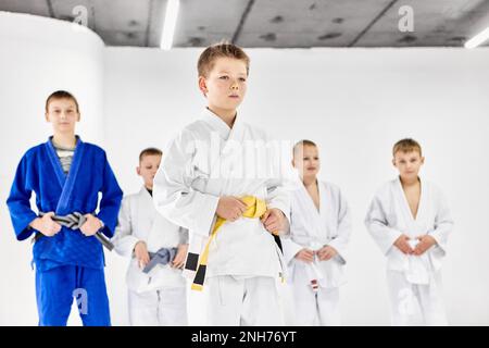 Portrait of boys, children in kimono. judo, jiu-jitsu athletes posing with serious facial expression Stock Photo