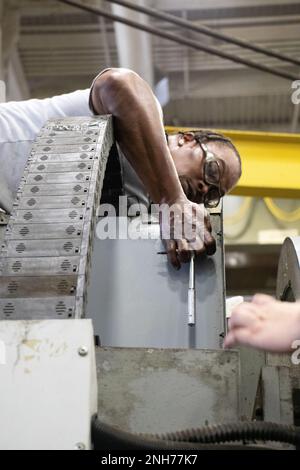 Sydney Ethridge, electronic industrial controls mechanic, Rock Island Arsenal – Joint Manufacturing and Technology Center, Rock Island Arsenal, Ill., safely climbs to all heights to keep the factory’s equipment running ensuring continued production of quality equipment to warfighters. Stock Photo