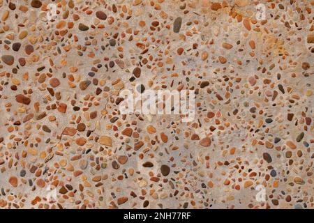 Colored pebble stone wall of the building exterior. Abstract construction design background Stock Photo