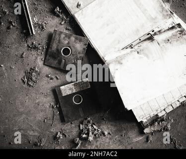 Dirty and obsolete floppy disks and folder on the ground. Stock Photo