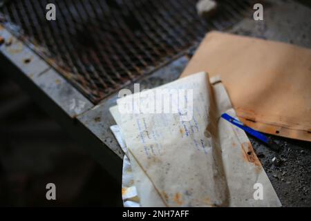 Obsolete torn folder with handwritten notes on work documentation in German. Stock Photo