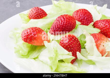 Healthy summer diet salad with strawberries and leaves iceberg lettuce. Light snack, healthy food. Copy cpace Stock Photo