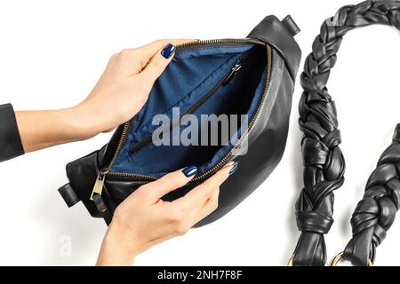 Female Hands Opening Black Genuine Leather Waistbag Showing Blue Fabric Inner Lining. Handmade Leather Goods Manufacture Stock Photo