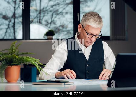 Mature businessman working at the desk in office. Stock Photo