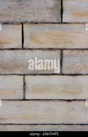 Worn and weathered wall made out of natural limestone masonry blocks. Stock Photo