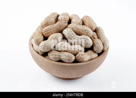 Bowl full of shelled peanuts on white background Stock Photo