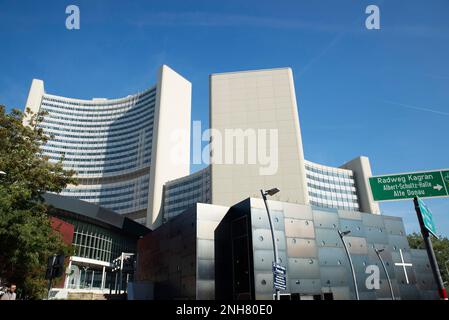 Vienna, Austria - October 17, 2022: Church and the facade of the headquarters of International Atomic Energy Agency or IAEA, a modern skyscraper in Do Stock Photo