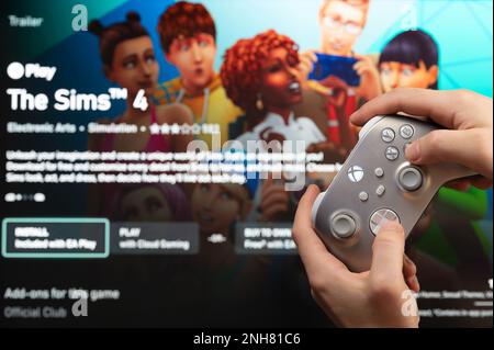 New york, USA - February 20, 2023: Gamer start new The Sims  4 Game on xbox console with joystick in hand Stock Photo