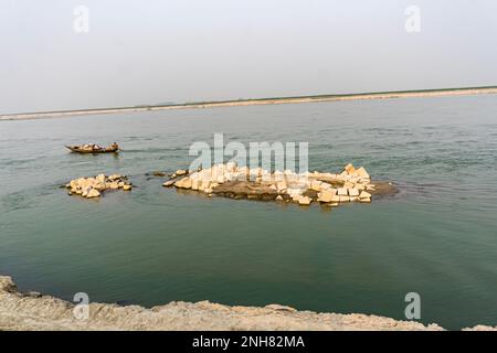 Cement block isolated on river. Gray Cement Cinder Block Isolated On river side. Granite bolder in infront of river. Stock Photo