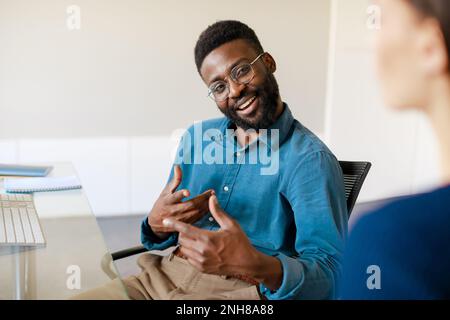Positive african american businessman explaining new responsibilities to female applicant Stock Photo