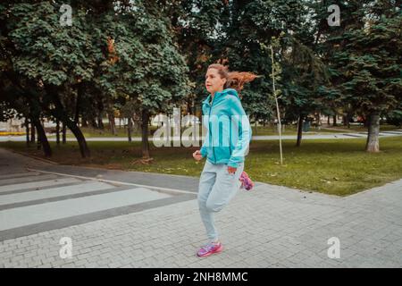 Cheerful active girls wearing sports clothes running and crossing the  street Stock Photo - Alamy