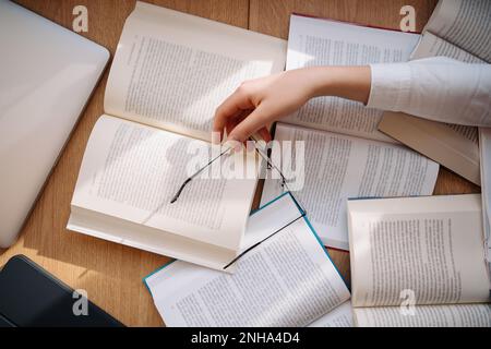 Tired student got asleep on the desk while studying among books Stock Photo