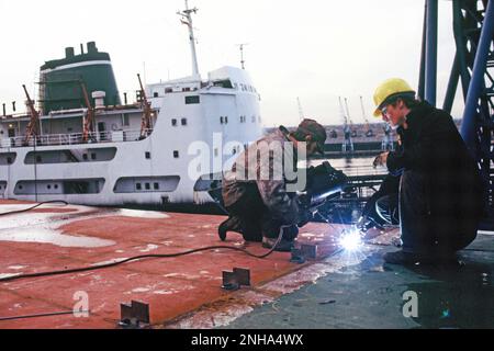 United Kingdom. England. Industry. Ship building. Men welding on ship deck. Stock Photo
