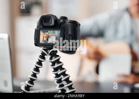 camera recording video of man playing guitar Stock Photo