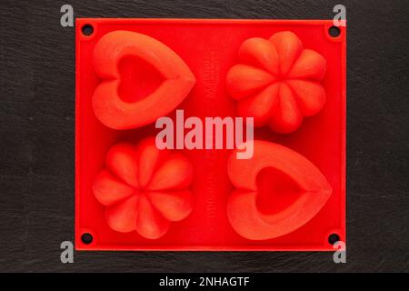 Red silicone cookie cutter on slate stone, macro, top view Stock Photo