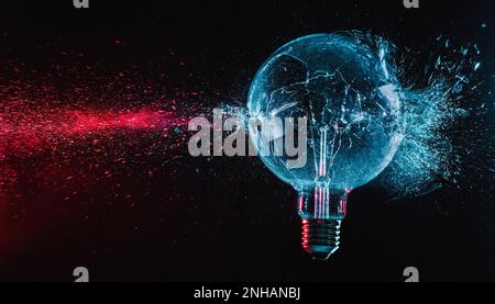 large blue bulb shatters and creates fragments of red glass. Stock Photo