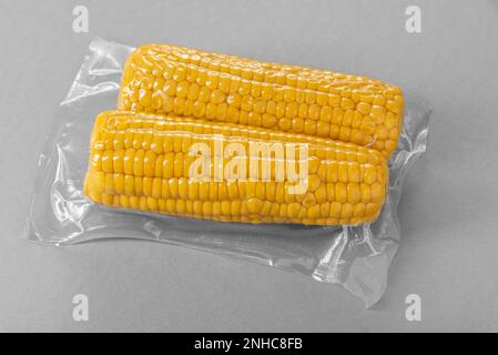 Corn cob in vacuum pack for sous vide cooking on gray background Stock Photo
