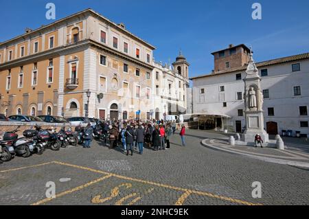 Guided tour in Piazza di San Bartolomeo all'Isola (on the right marble monument by Ignazio Giacometti,1869),Tiber Island (Isola Tiberina), Rome, Lazio Stock Photo