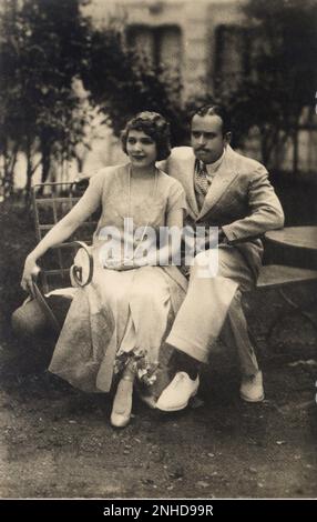 1929 ca.  :  The silent movie actor DOUGLAS FAIRBANKS Sr. ( born Douglas Elton Ulman , Denver , Colorado 1883 - Los Angeles , CA  1939 ) with his wife MARY PICKFORD ( Toronto 1893 - santa Monica 1979 )  - CINEMA MUTO - FILM - portrait - marito e moglie - innamorati - lovers - panchina - perals necklace - collana di perle - perla - jewels - gioielli - gioiello - baffi - moustache  ----    Archivio GBB Stock Photo