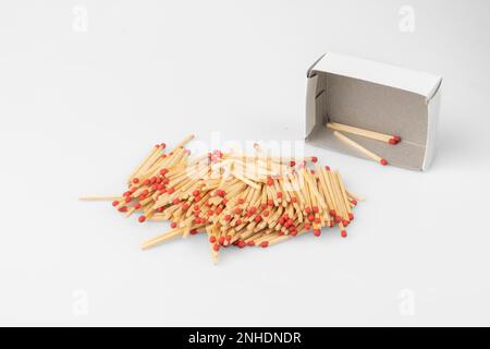 Stack of matches in front of almost empty box, white background Stock Photo