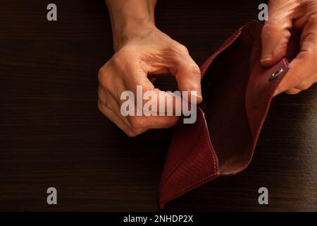 old woman's hands opened their empty wallet on the background Stock Photo