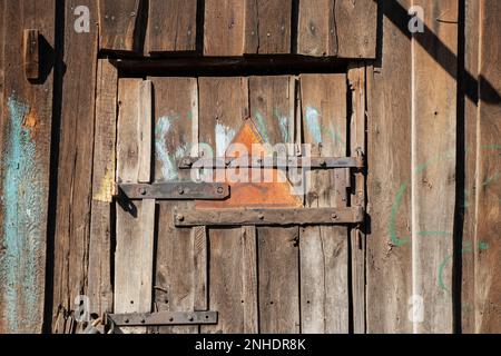 iron sign with skull and bones warning of danger on wooden old door as background Stock Photo