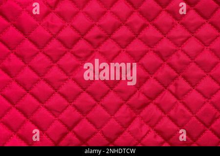 red stitched quilted bag cloth background closeup Stock Photo