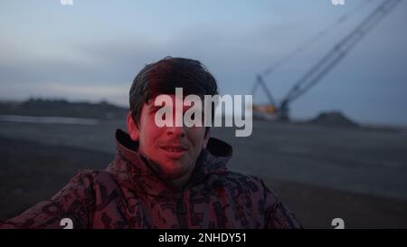 Serious Man Waving Red Light by Side of Road and Looking at Camera, Working Concept Stock Photo