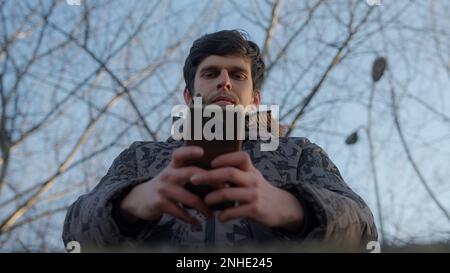 Man Using his Smartphone for Messaging and Applications, Bottom view Stock Photo