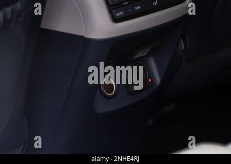 Modern car outlet socket. Opened 12V power outlet socket and 220v power outlet socket in the car. Opened sockets. Stock Photo