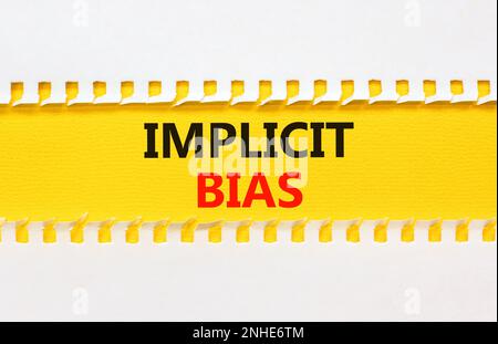 Implicit bias symbol. Concept words Implicit bias on yellow paper. Beautiful yellow table white background. Business psychology implicit bias concept. Stock Photo