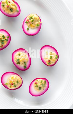 A platter of homemade beet juice soaked devilled eggs for an Easter celebration. Stock Photo