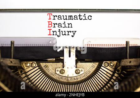 TBI traumatic brain injury symbol. Concept words TBI traumatic brain injury typed on retro old typewriter on a beautiful white paper background. Medic Stock Photo