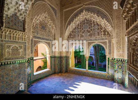 Fantastic old of Moorish  art  with interior of  room in palaces of Alhambra carves in stone and wall ceramic tiles;  whimsical flower ornaments of f Stock Photo