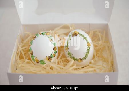 Easter eggs pastel colored in egg box on light background with copy space. Minimal Easter celebration concept, dyed chicken egg with color gradient from blue to beige coloured in carton pack Stock Photo