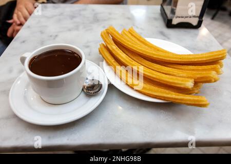 Churros and chocolate sauce at famous Chocolateria San Gines - the oldest churreria and chocolateria in Madrid, Spain Stock Photo