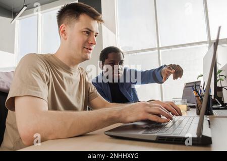 Two programmers working in the office of a software development company. Coding technologies, site design. Successful diverse Teamwork. Cyberspace Stock Photo
