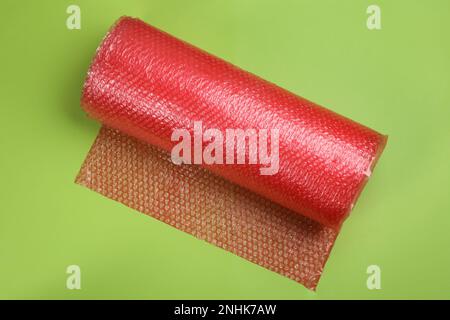 Bubble wrap roll on green background, top view Stock Photo