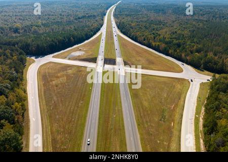 View from above of busy american highway with fast moving traffic between woods. Interstate transportation concept Stock Photo