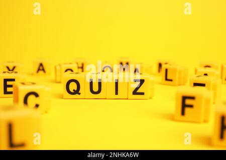 Cubes with word Quiz on yellow background. Space for text Stock Photo