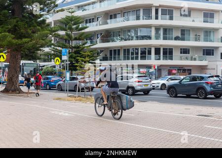 Man on his bicycle carry surfboard, Manly Beach,Sydney,NSW,Australia summer 2023 Stock Photo