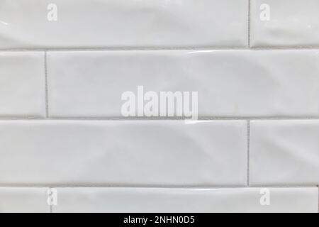 White uneven handmade wavy extra long subway tile for a backsplash, shower, bathroom wall area Stock Photo