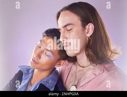 Cyberpunk, tired and gay couple sleeping in makeup isolated on a pink background in studio. Futuristic, lgbt freedom and men friends napping for Stock Photo
